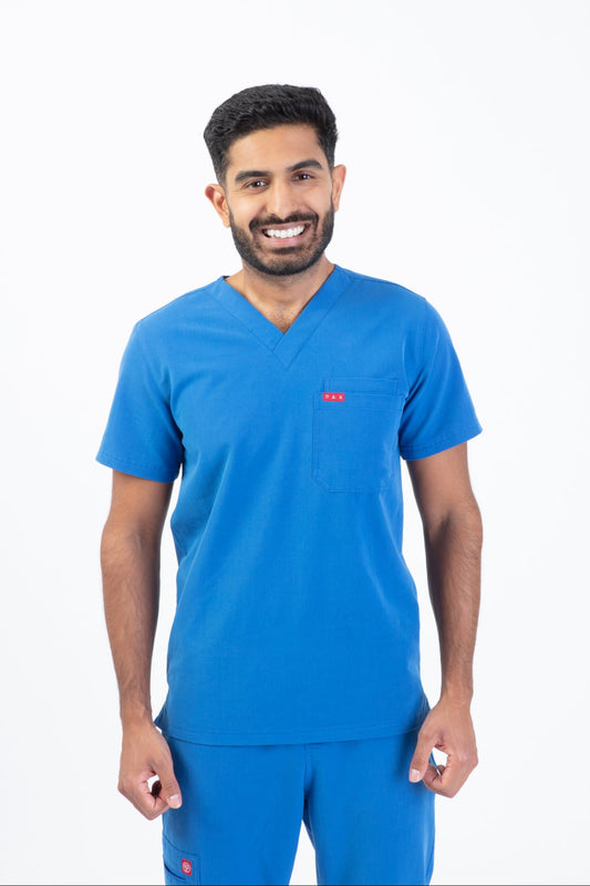Man wearing a blue scrub set with a visible brand logo on a white background