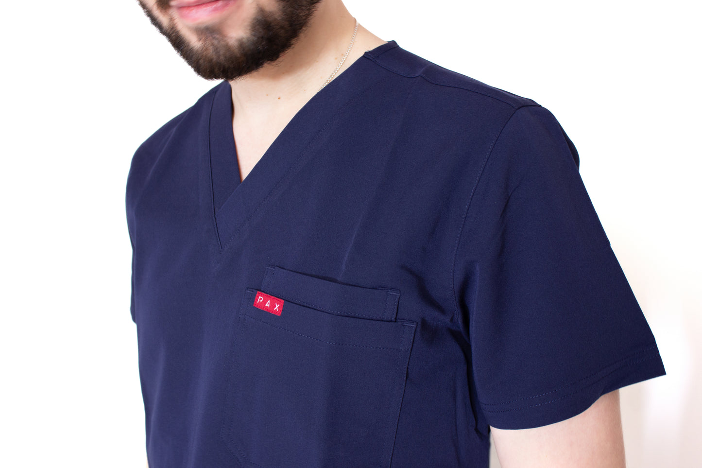 Close up of Male scrub top double breast pocket with carmine PAX branding