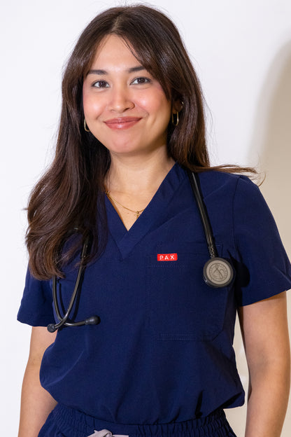 PAX Core Luma women's navy scrub top, close front view with a stethoscope