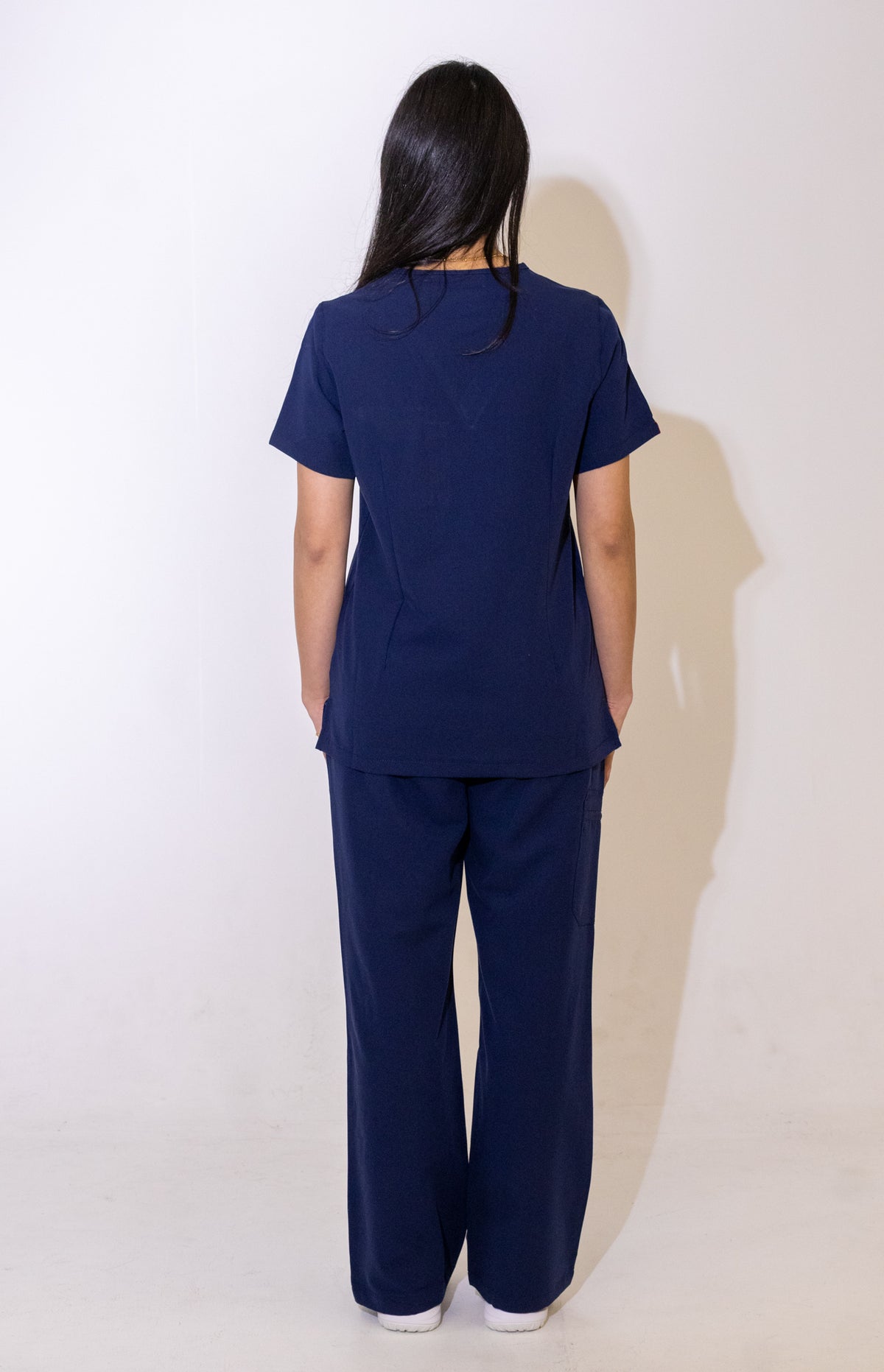 PAX Core Luma women's navy wide-leg scrub trousers, full-length back view with the matching top