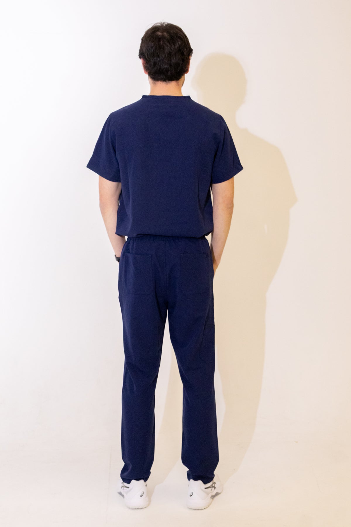 PAX Core Sequi men's navy straight-leg scrub trousers, full-length back view with the matching top