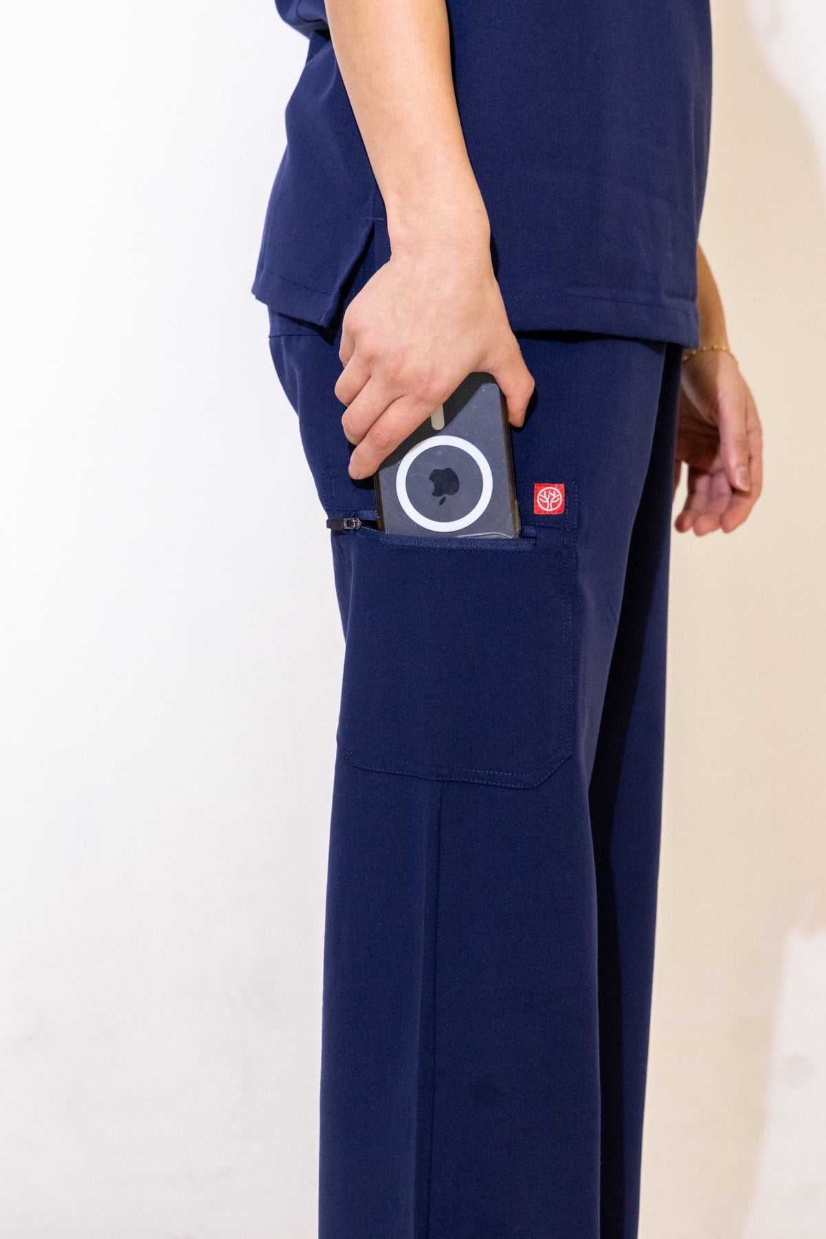 PAX Core Luma women's navy wide-leg scrub trousers, cargo pocket detail with a device