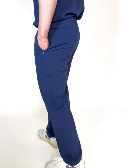 Healthcare worker with hand in the zippered hip pocket of blue PAX scrub bottoms.