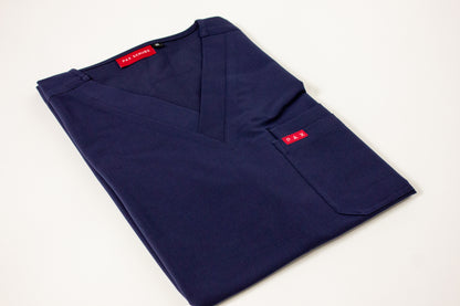 Folded royal blue PAX scrub top with V-neck and carmine red brand tag.