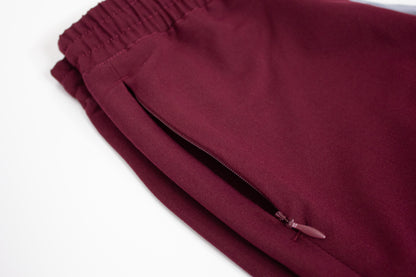 Close-up of PAX Primus scrub fabric in crimson with zipper detail.