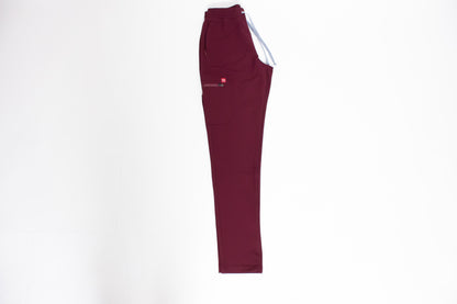 PAX Primus crimson scrub pants with grey drawstrings on white surface.