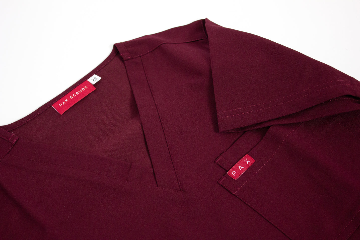 Crimson PAX Primus scrub top with V-neck and chest pocket.