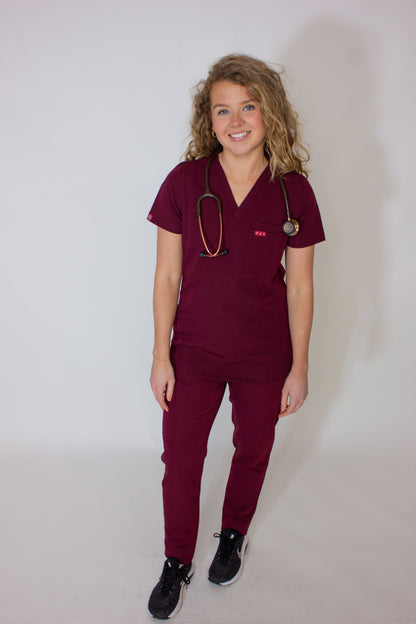 Female doctor in crimson red PAX Primus Scrubs with a stethoscope.