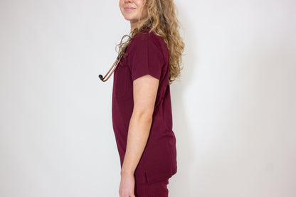 Side profile of a female doctor in a PAX Primus scrub top.