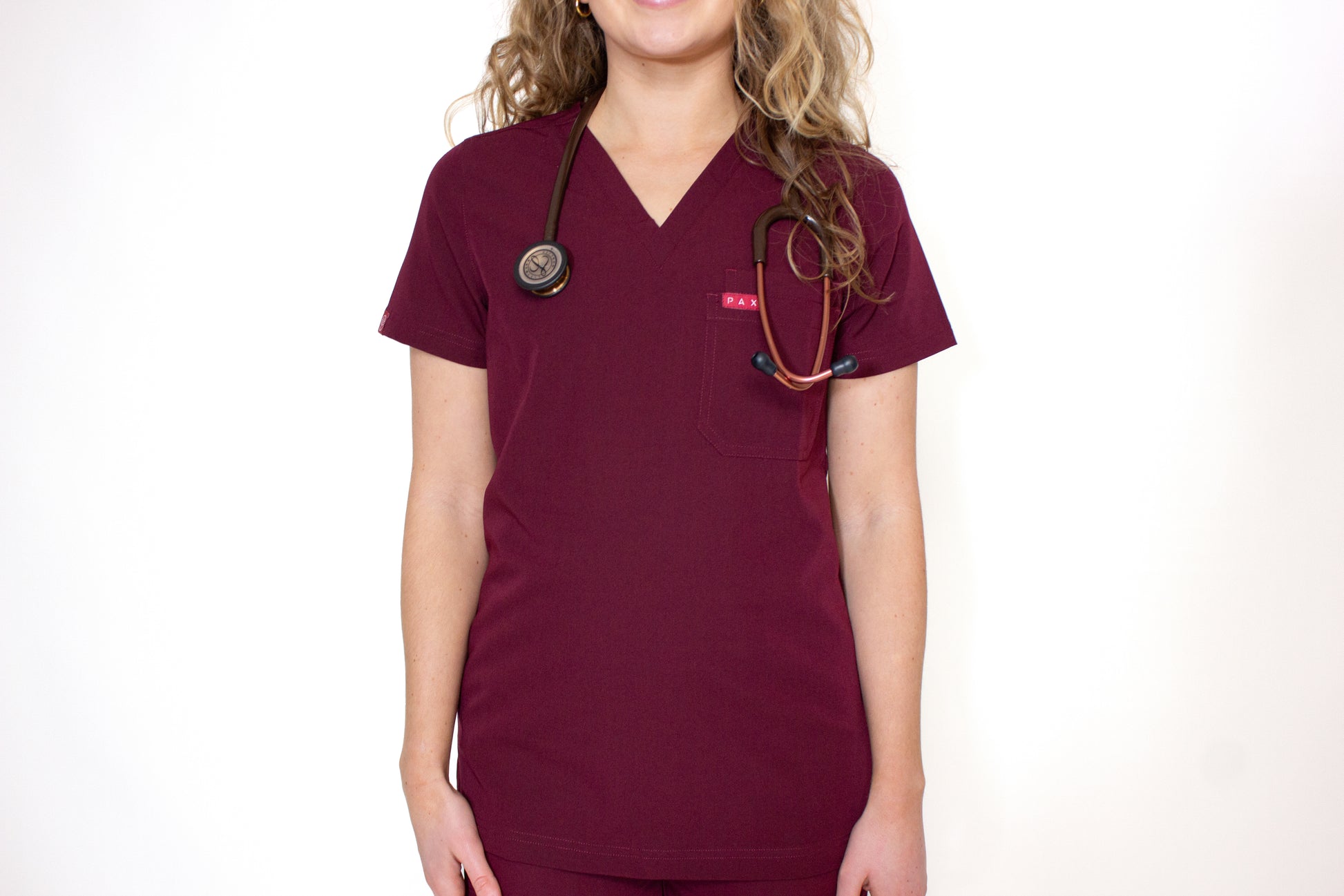 Front view of a PAX Primus women's scrub top in burgundy.
