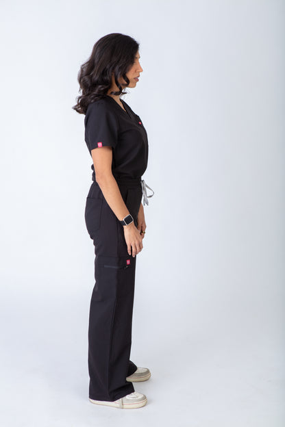 Person wearing a black scrub set on a white background