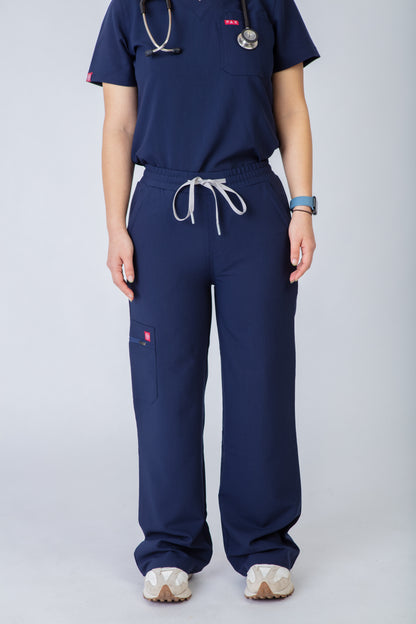 Person wearing navy blue scrubs with a stethoscope on a light gray background