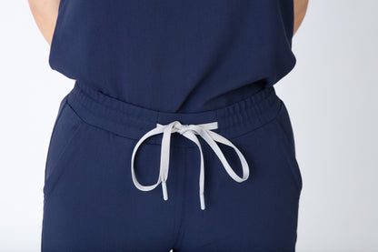Navy blue scrubs pants with a white drawstring on a white background