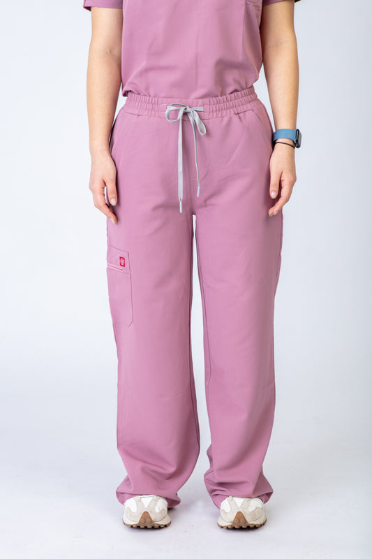 Person wearing pink scrubs with a white background