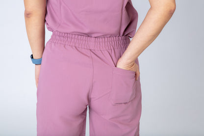 Person wearing a pink outfit with a plain background