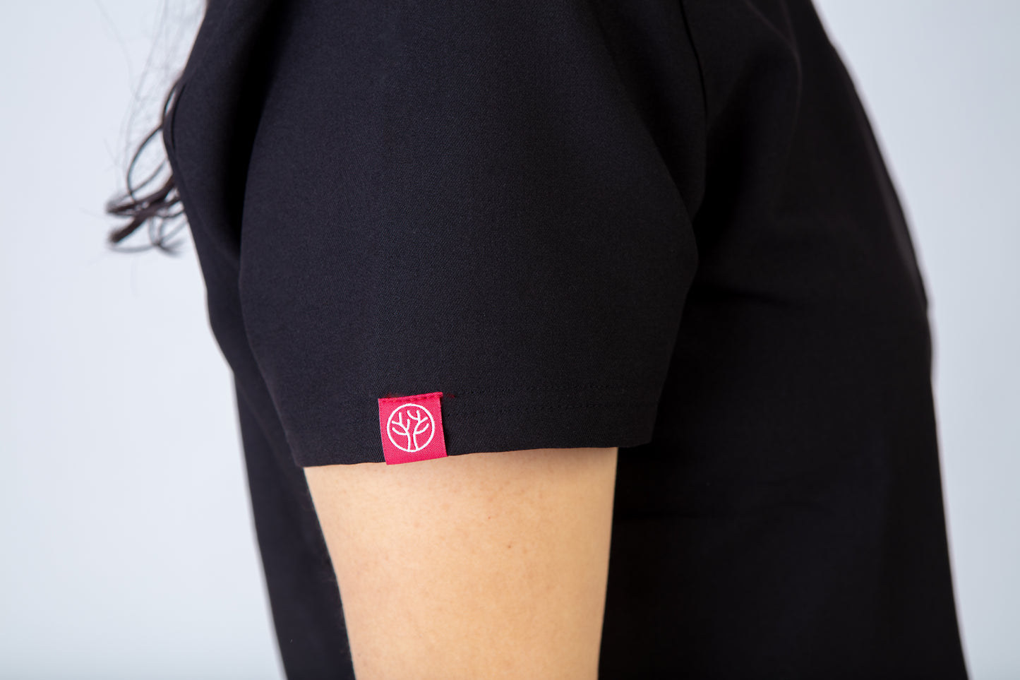 Black scrub top with a red PAX logo on a plain background