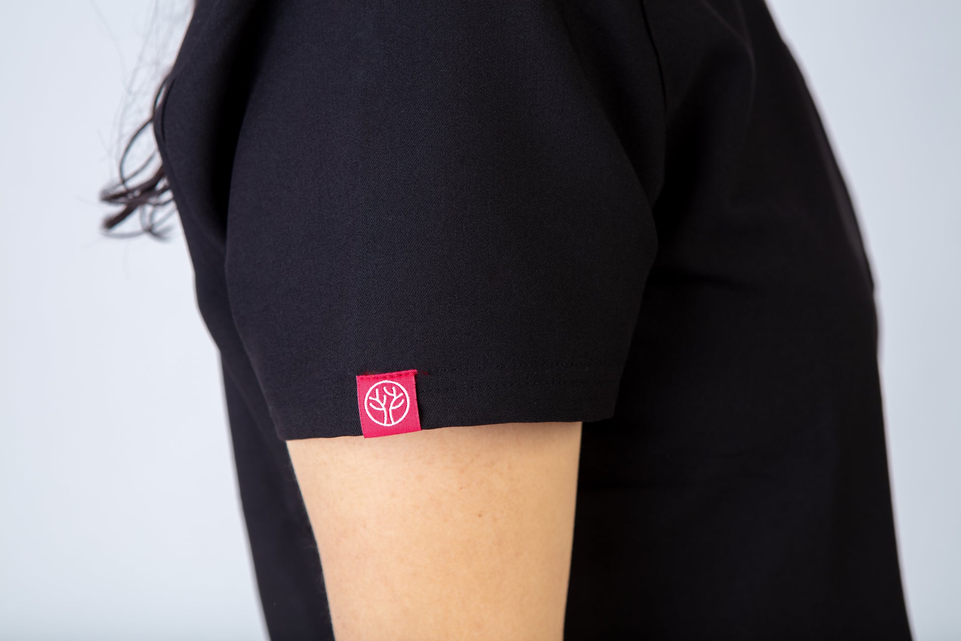 Black scrub top with a red PAX logo on a plain background