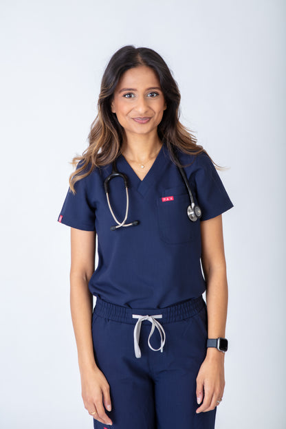 Person wearing navy blue medical scrubs with a stethoscope on a white background
