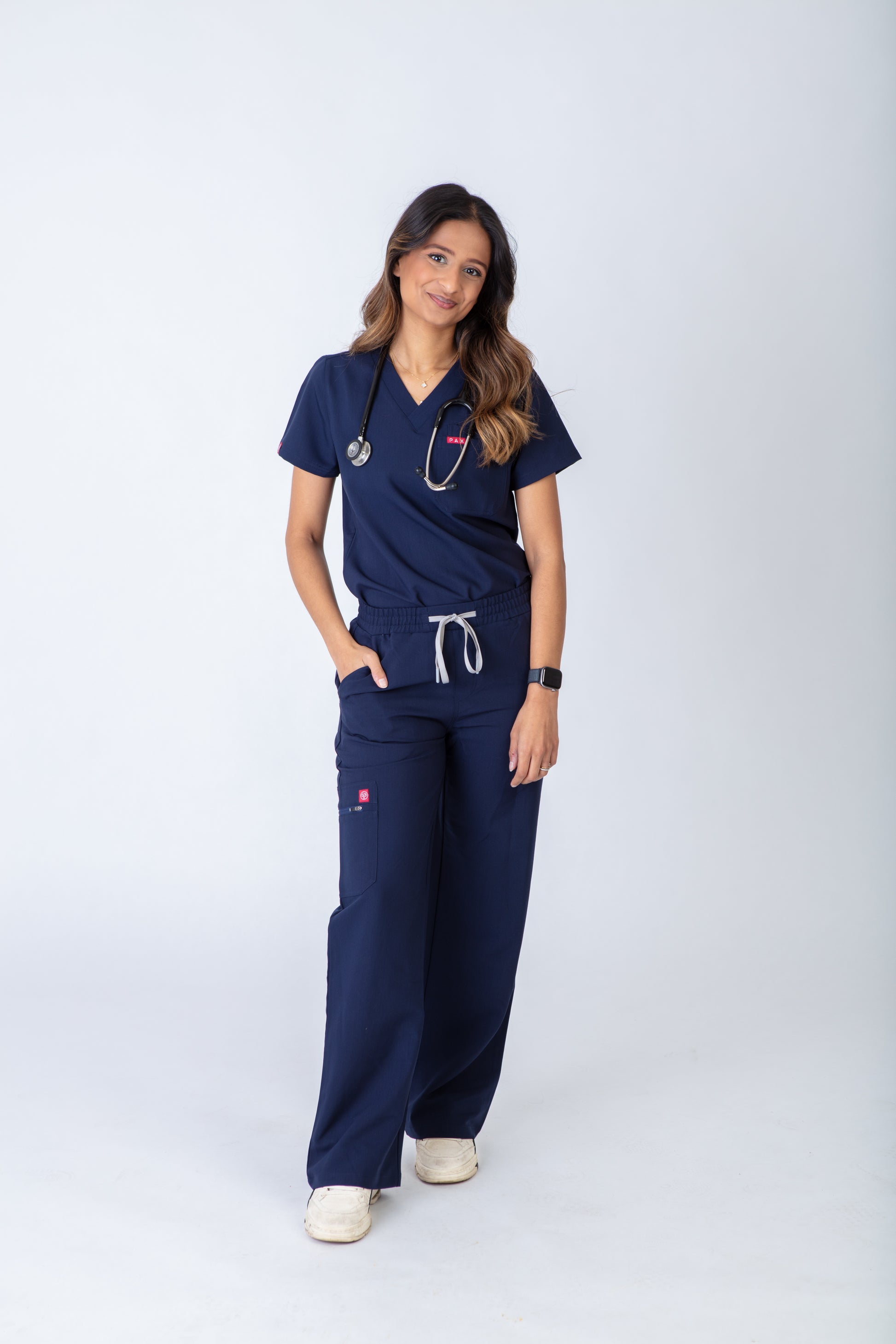 Person wearing navy blue scrubs on a white background