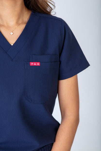 Navy blue scrub top with a red Pax logo on a white background