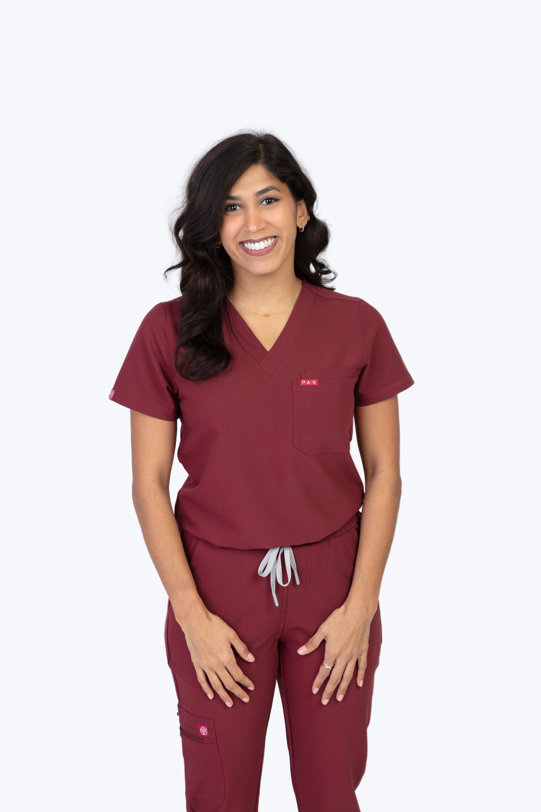 PAX Sequi women's burgundy scrub top, front view on model